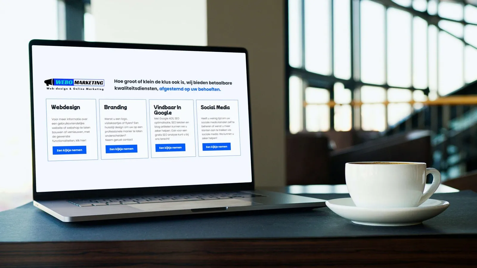 Een laptop toont de website van Webomarketing met de onderdelen webdesign, branding, vindbaar in Google en sociale media, naast een kop koffie
