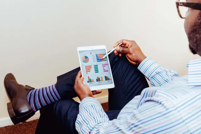 Een ondernemer bekijkt de grafieken van zijn bedrijf op een tablet