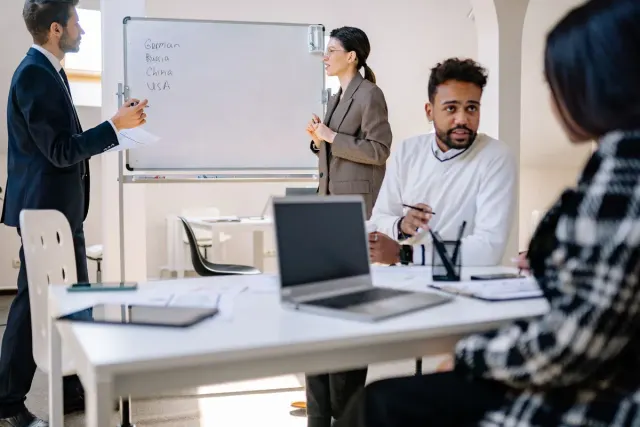 Een team bespreekt een plan aan een whiteboard